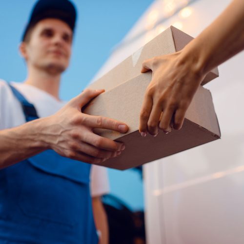 deliveryman-gives-parcel-to-female-recipient-2021-08-27-09-54-31-utc